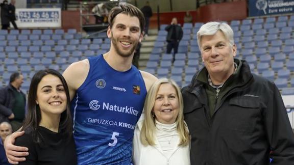 Jane Carlson posing with her family at a basketball game