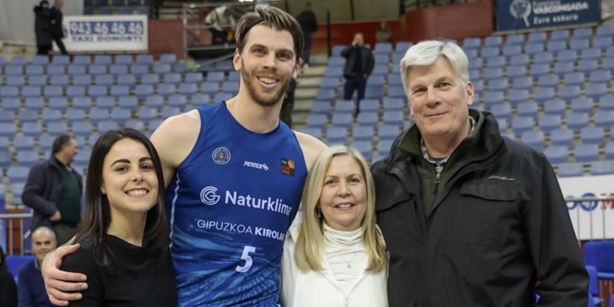 Jane Carlson posing with her family at a basketball game