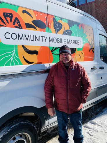 Karl Becker in front of the community mobile market van