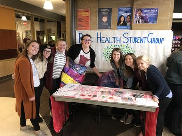 Members of the public health student group gathered around a tabling booth