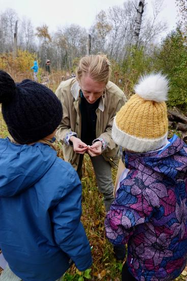 Moss Schumacher and two students looking at a mushroom