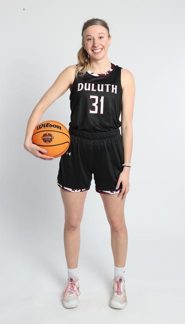 Ella Gilbertson holding a basketball in uniform with a white background