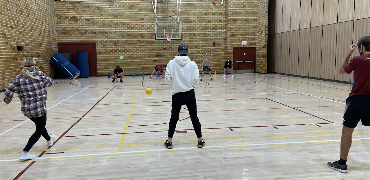 college students practicing goalball in a gym