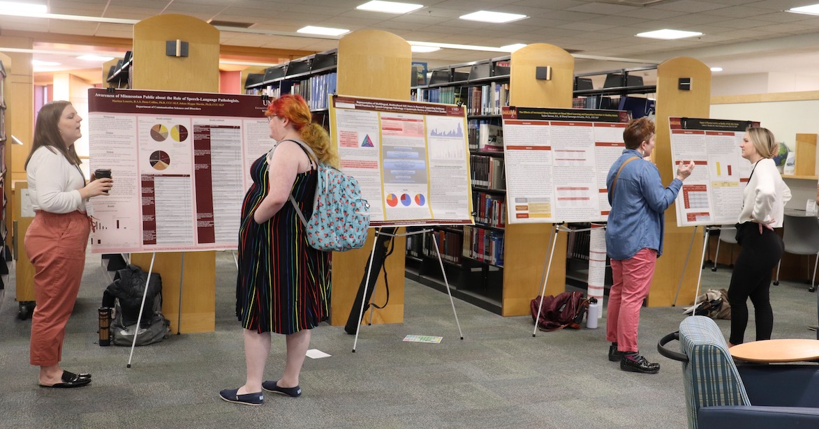 Two students present their work to people
