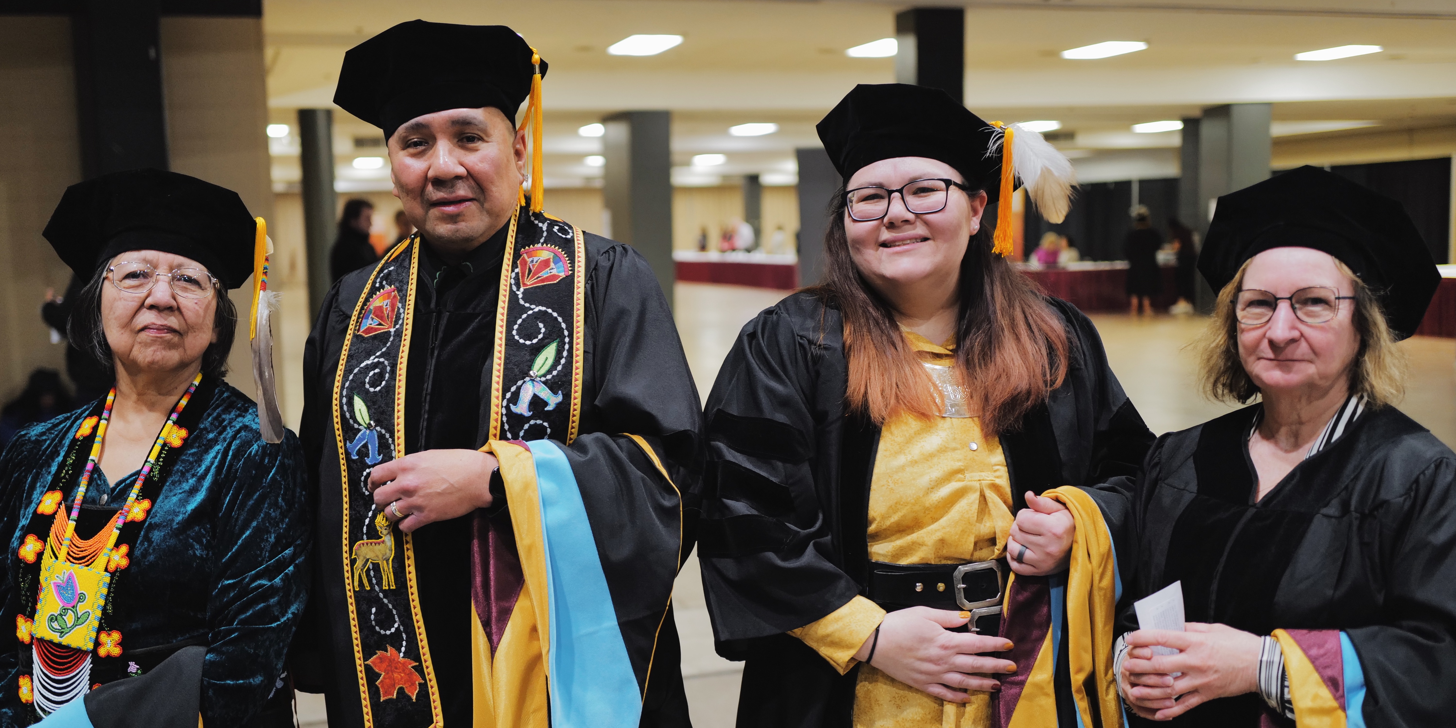 Four Indigenous educational doctorate graduates in their gowns at commencment in 2023