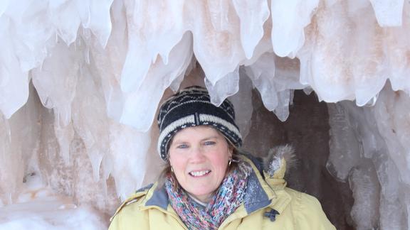 Shelley Michalicek, Administrative Associate 2 from UMD smiling for a photo in front of an ice-filled cave