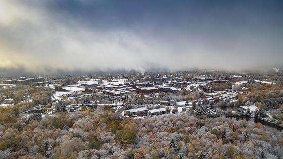 drone photo of campus with fall colors and snow