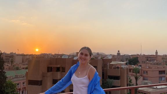 Brianna Raddatz with a Moroccan sunrise and view behind her
