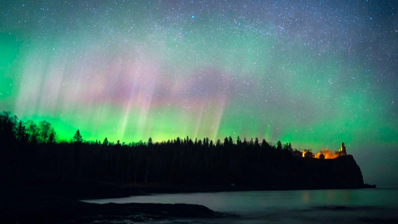 Northern lights with vivid green and purple displayed over a lake
