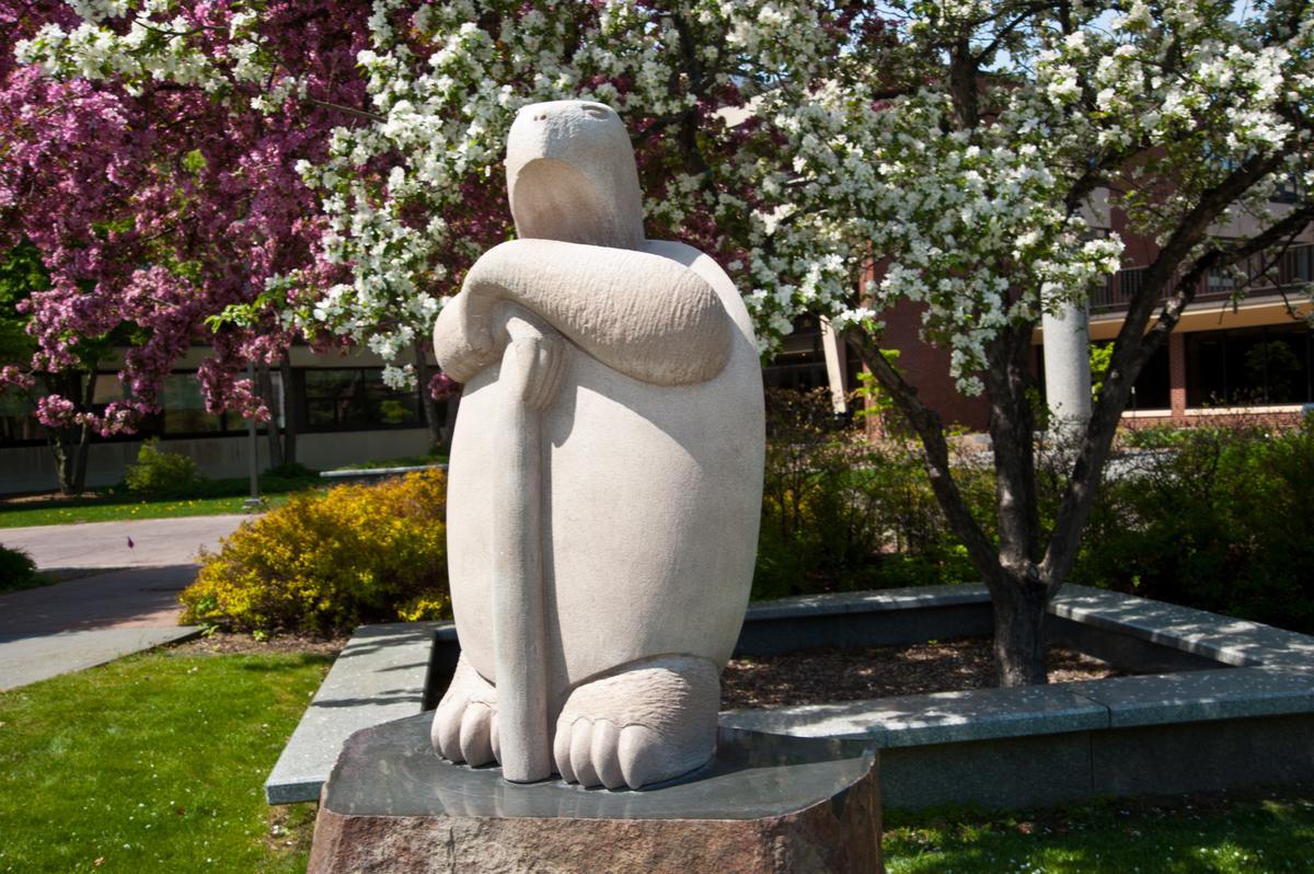 white statue with flowering trees in background