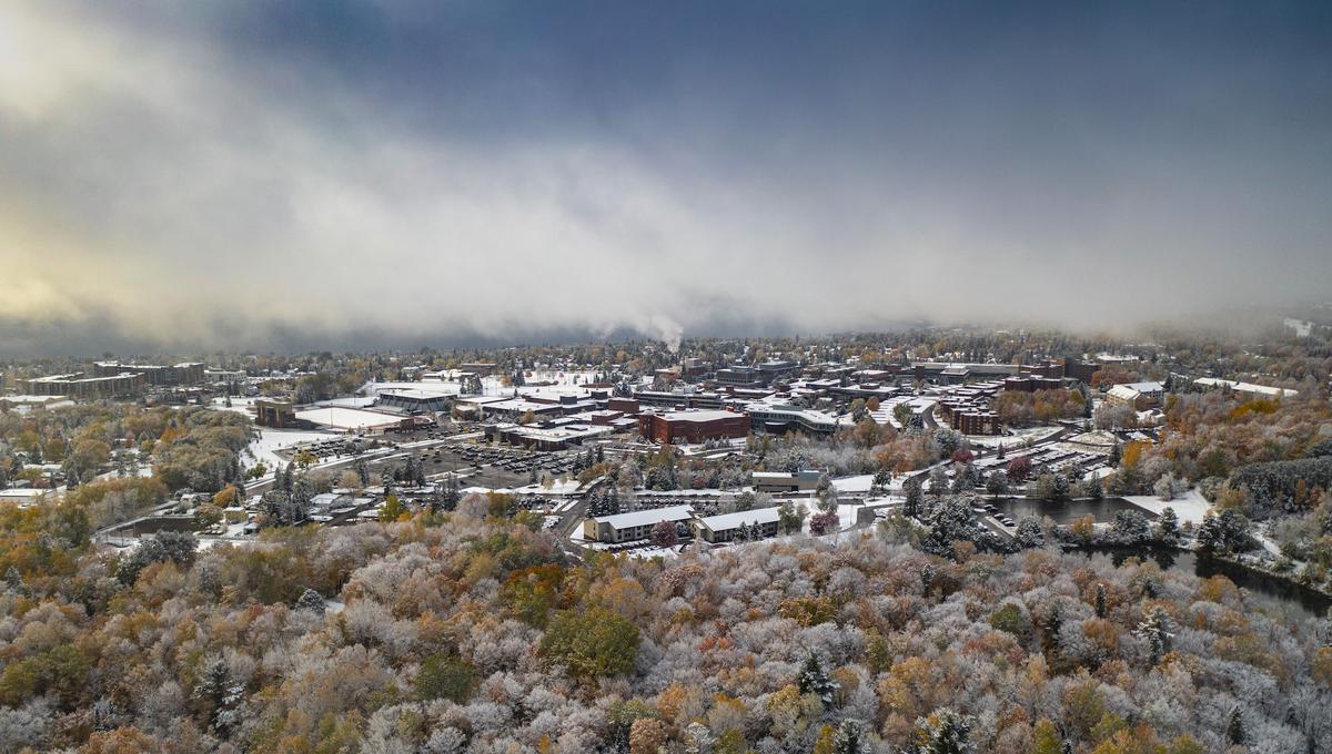 drone photo of campus with fall colors and snow