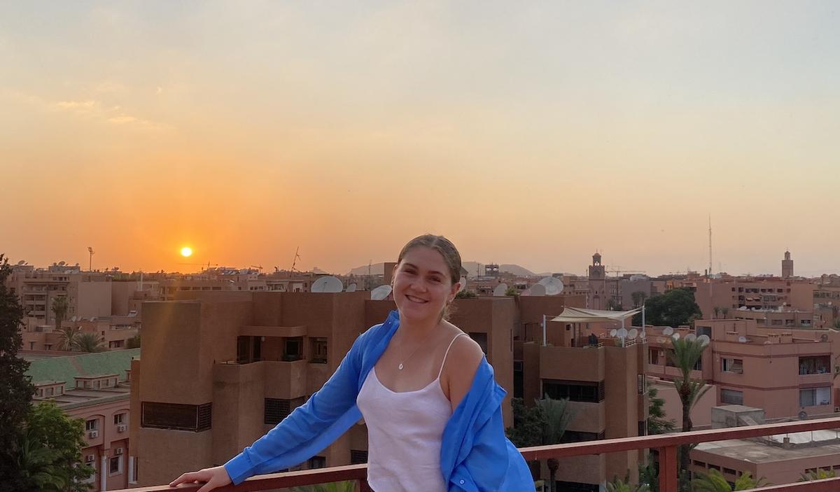 Brianna Raddatz with a Moroccan sunrise and view behind her