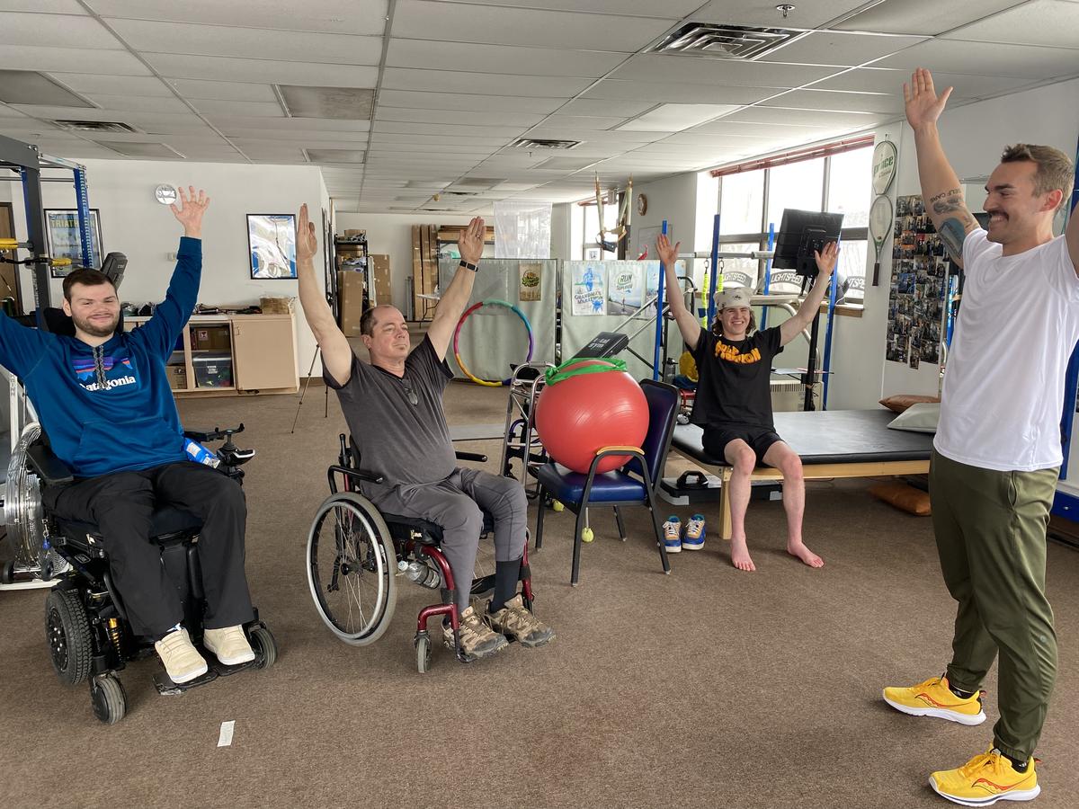 Blake Peters leading clients in wheelchairs in exercise