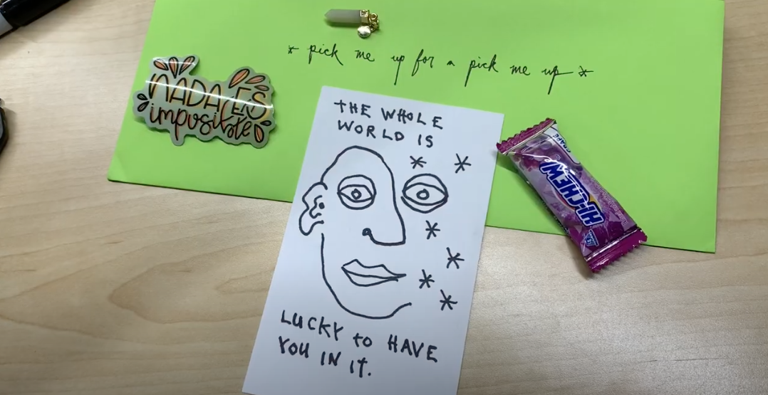 Note, drawing of face and candy. Note reads, "The world is lucky to have you in it."