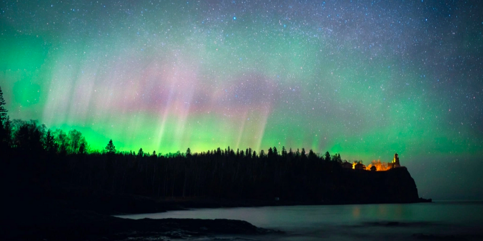 Northern lights with vivid green and purple displayed over a lake