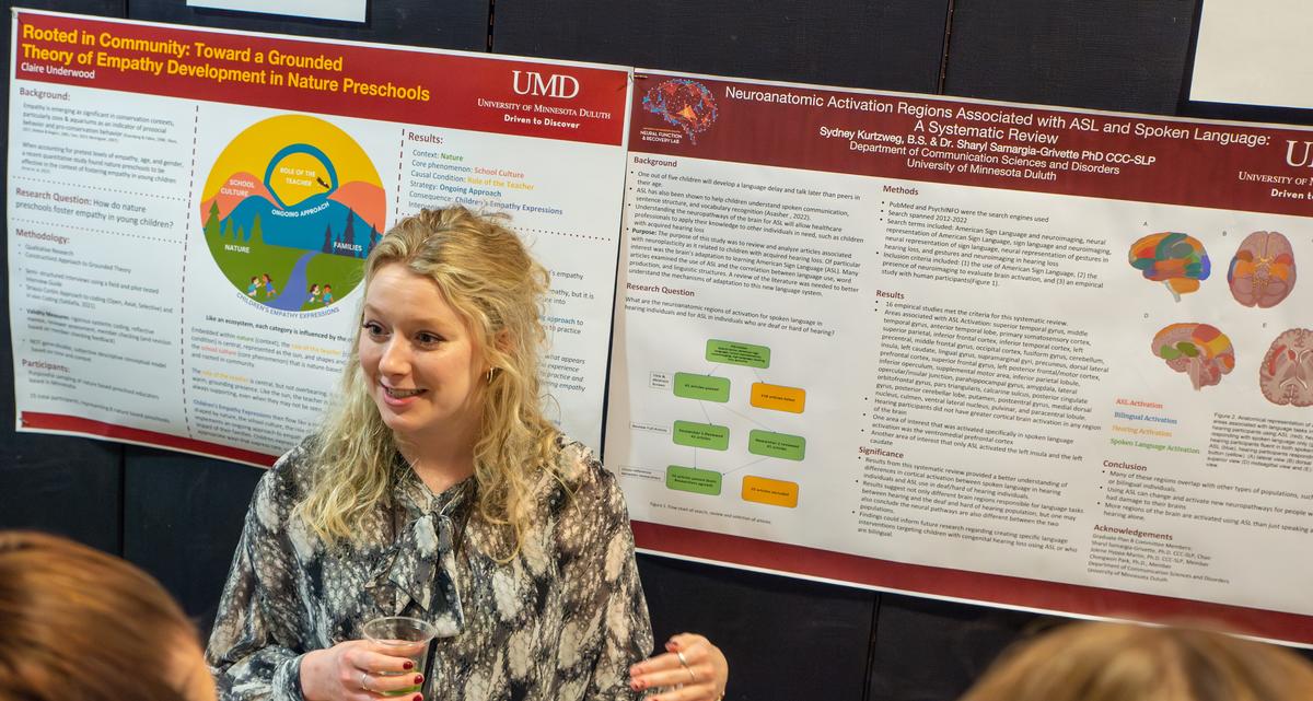 a students happily presenting her undergraduate research 