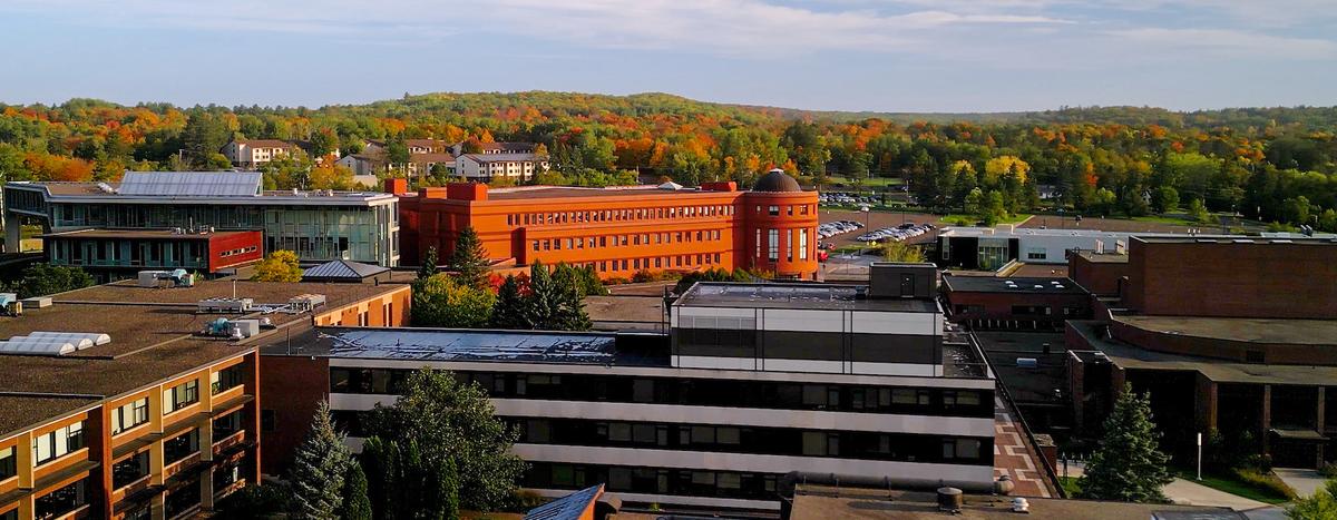 fall aerial view of campus, including colorful trees in background