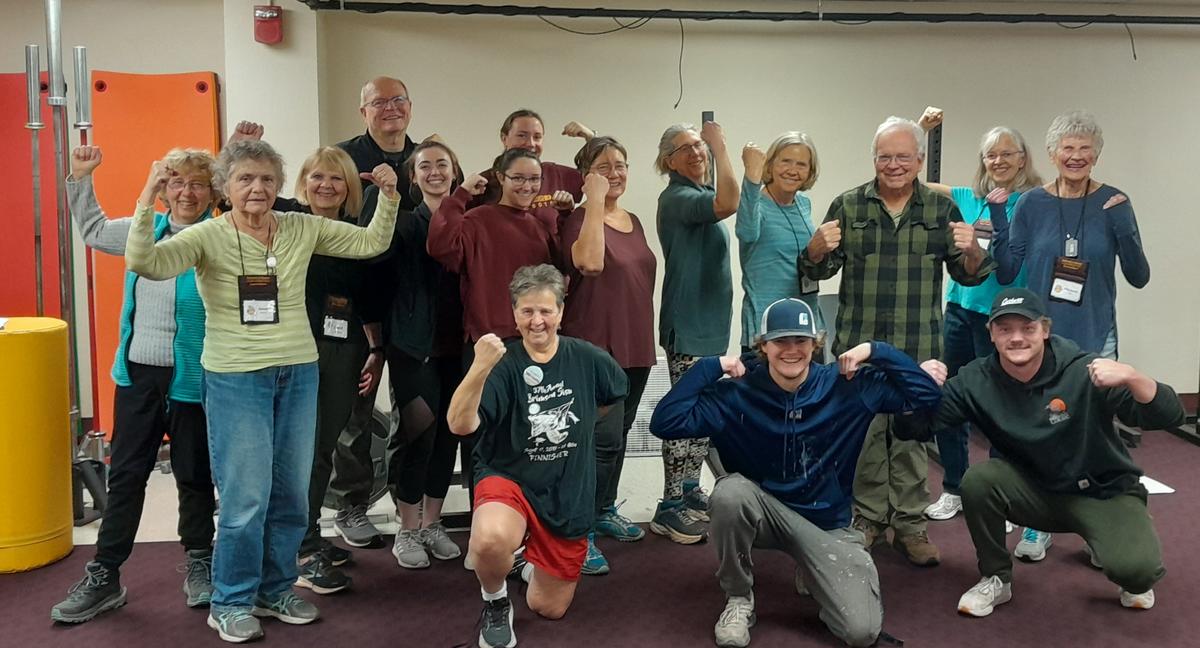Chuck Fountaine, his student assistants, and Resistance Training for Seniors participants flexing 
