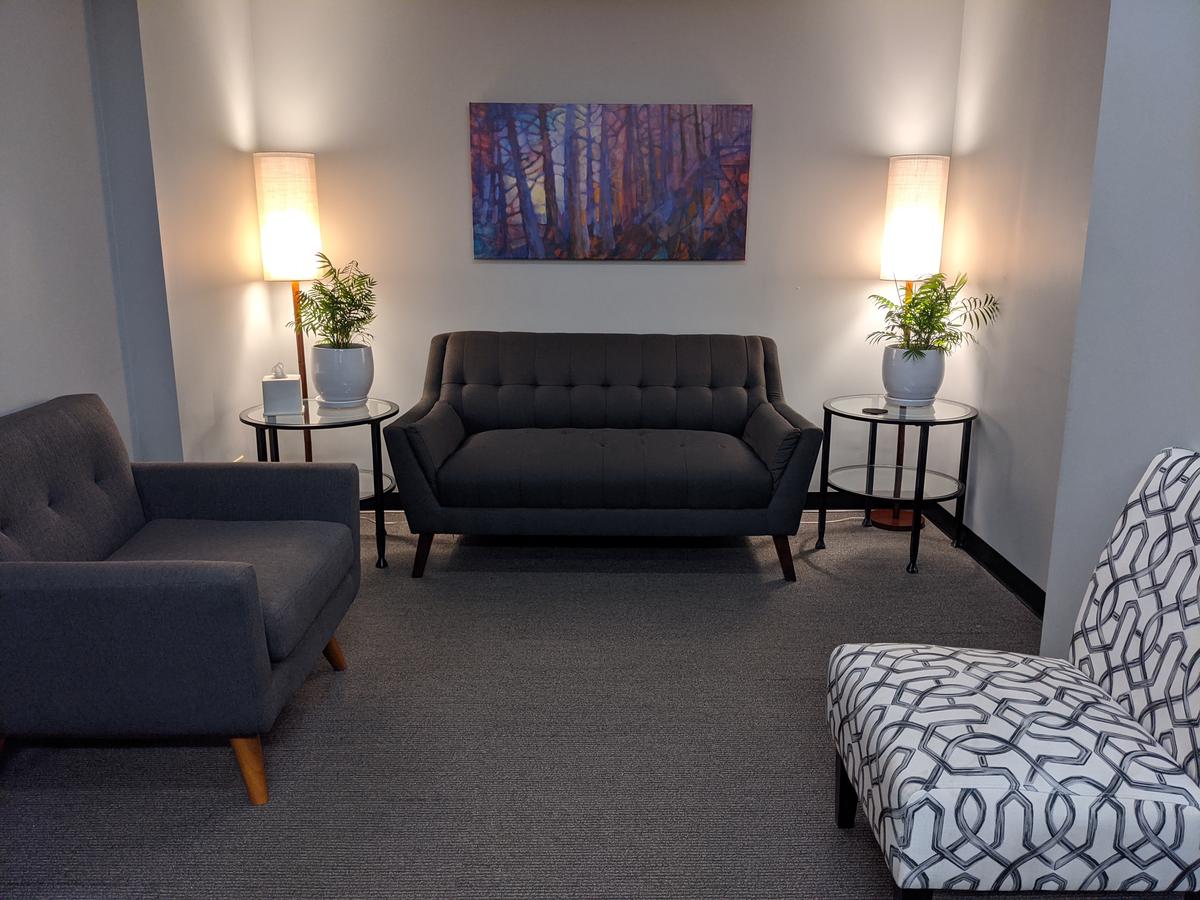 waiting area for MAP Behavioral Health Center with couches, soft lamp lights, and plants on two end tables