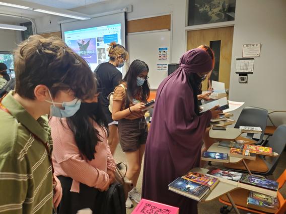 A group of UBVQ students looking at books in a classroom