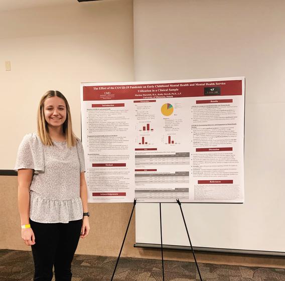 Marissa Maroslek stands with pride next to her research board