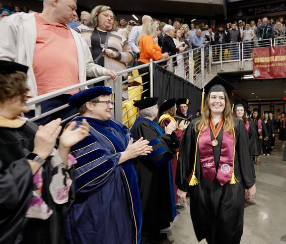 Gavi Gunther walking at commencement with people clapping