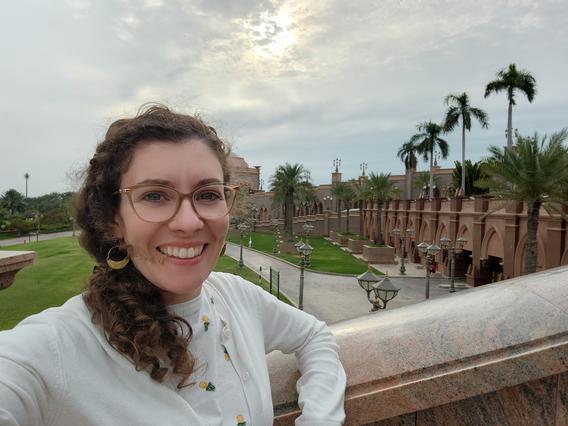 Elizabeth Boileau, smiling with palm trees and the ornate Emirates Palace Mandarin Oriental hotel in the background