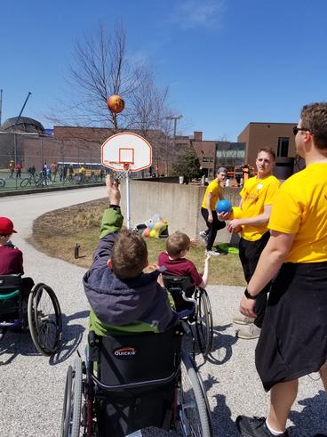 students outside playing wheelchair basketball