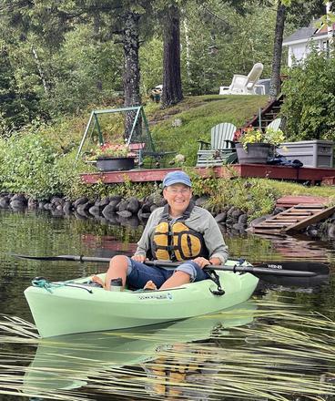 Helen Mongan-Rallis at the cabin in a green kayak