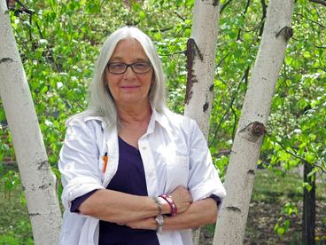 Linda Grover posing in front of a birch tree
