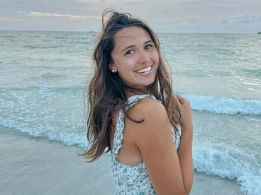 Anna Buckmeier Smiling in front of an ocean