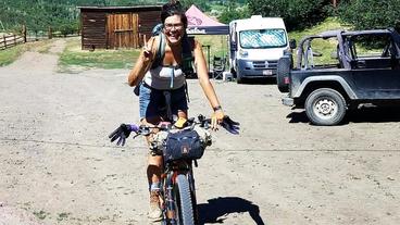 Alexandera Houchin flashing a peace sign atop her bike at the Brush Mountain Lodge during the Tour Divide