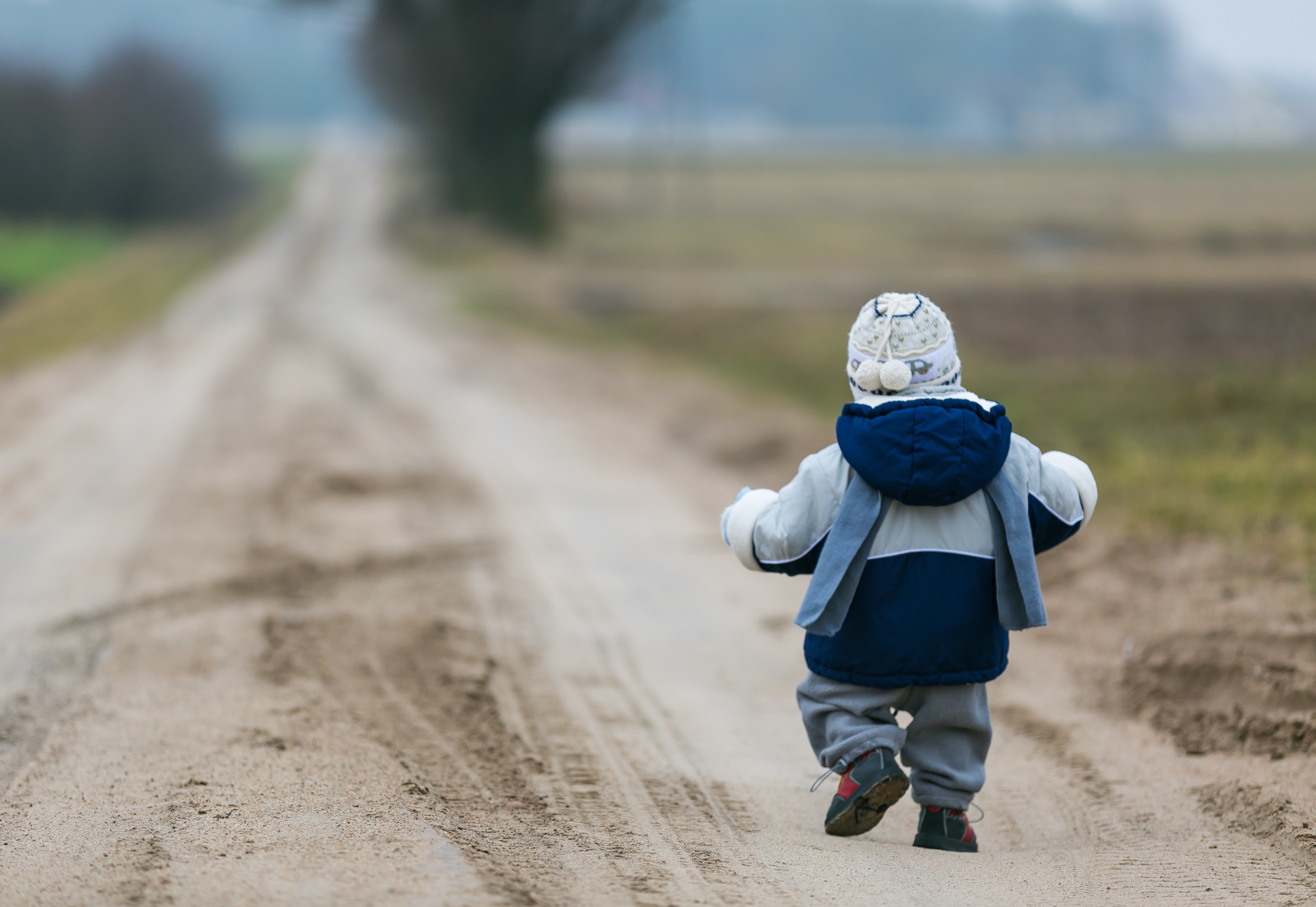 Toddler walking on dirt road
